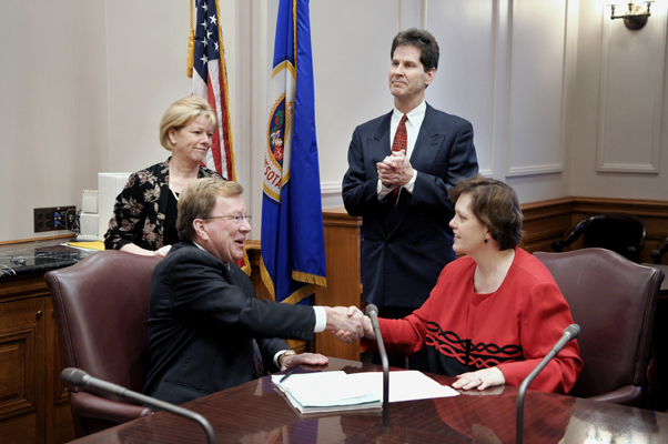 Senate President James Metzen and House Speaker Margaret Anderson Kelliher congratulate each other after signing the overridden transportation bill into law. Second Assistant to the Secretary of the Senate Colleen Pacheco and Senate Majority Leader Larry Pogemiller witness the signing.