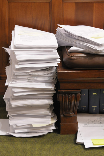 Omnibus bills are subject to amendments, like this stack waiting to be considered for the omnibus tax bill. Amendments can further complicate a member’s vote. (Photo by Tom Olmscheid)