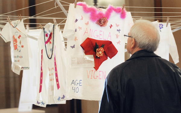 Karl Porisch of Marshall stops at the shirt of Angela Vigen that was hanging in the Capitol Feb. 2 as part the Clothesline Project. Each shirt is created to visually memorialize the casualties of domestic violence to women and children. Vigen was killed on Oct. 27, 2008, by her boyfriend, who had a history of domestic violence. (Photo by Tom Olmscheid)