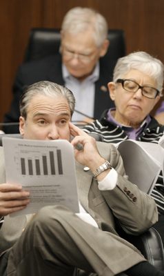 Rep. Michael Paymar, from bottom, Rep. Phyllis Kahn and Rep. Thomas Huntley follow a budget handout March 4 as State Economist Tom Stinson reviews the February Forecast with members of the House Ways and Means and Finance 
committees. (Photo by Tom Olmscheid)