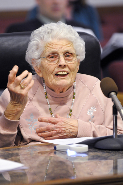 Irene Long, 91, tells members of the House Game, Fish and Forestry Dvision March 23 how, for a photo, she had a hard time getting her arms around a 54-inch muskie she caught. The division was hearing a bill that would provide free fishing licenses for residents at least 90 years of age. (Photo by Tom Olmschied)