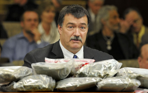 Behind a pile of processed marijuana, Bob Bushman, president of the Minnesota State Association of Narcotics Investigators, testifies before the House Public Safety Policy and Oversight Committee on March 24 in opposition to a bill that would provide medical marijuana use. The bags of marijuana were brought to the committee as a visual aid to show how much a person could grow if they had 12 plants. (Photo by Andrew VonBank)