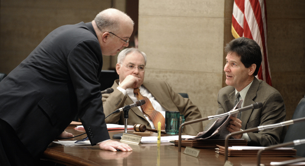 Prior to a Feb. 16 hearing of the LCPFP Subcommittee on a Balanced Budget, House Finance Committee Chairman Rep. Lyndon Carlson, Sr., center, listens as he and Senate Majority Leader Larry Pogemiller, right, question Minnesota Management & Budget Commissioner Tom Hanson on the use of federal funds to balance Gov. Tim Pawlenty�s supplemental budget proposal. (Photo by Tom Olmscheid)