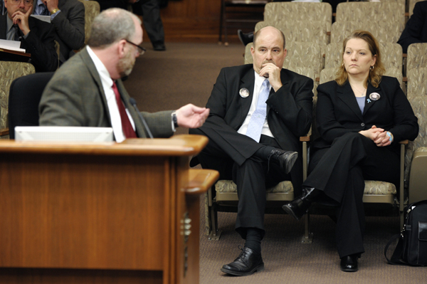 Michael McDermott, left, executive director of state public policy for Verizon Wireless, interrupts his testimony to express his condolences to Greg and Missy Smith for the loss of their daughter, Kelsey, who was taken from a Target Store in Overland Park, Kan., and found dead four days later. McDermott spoke in favor of a bill that would authorize wireless telecommunications service providers to provide call locations for emergencies. (Photo by Tom Olmscheid)