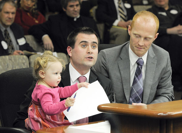 Chris and Ryan Dolan testify with their 2-year-old daughter, Olivia, before the House Civil Justice Committee Feb. 22 in support of legislation that would create gender-neutral marriage laws and recognize in Minnesota marriages performed in other states. (Photo by Andrew VonBank)