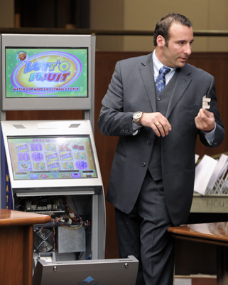 Representing the Tavern League of Minnesota, Dan Campo demonstrates a video pull-tab machine during a hearing of the House Commerce and Labor Committee Feb 25. (Photo by Tom Olmscheid)