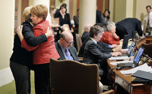 Rep. Erin Murphy, right, receives a hug from Rep. Patti Fritz after the House voted voted 121-12 March 24 to pass the GAMC compromise legislation. (Photo by Tom Olmscheid)