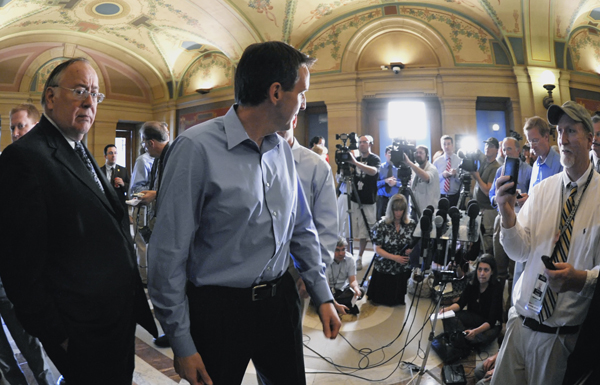 Senate Minority Leader David Senjem, left, waits as Gov. Tim Pawlenty turns back to answer one more reporter�s question May 16 after explaining his position on negotiations with the Legislature to balance the state�s budget. (Photo by Tom Olmscheid)