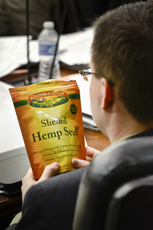 Rep. Kory Kath inspects a bag of hemp seeds during a March 9 discussion of a bill that would create an industrial hemp industry in Minnesota. The bills sponsor, Rep. Phyllis Kahn, provided the edible seeds to members of the House Agriculture and Rural Development Policy and Finance Committee. (Photo by Andrew VonBank)