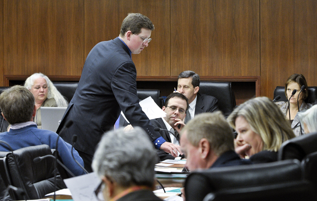 House Page Michael Mullen passes out amendments to the omnibus tax bill during the March 23 meeting of the House Ways and Means Committee. (Photo by Andrew VonBank)