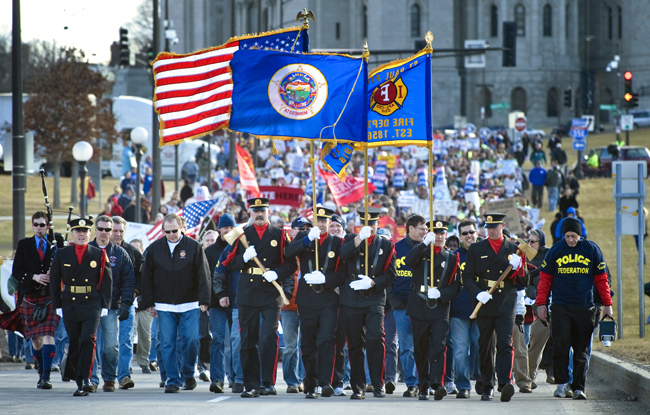 The St. Paul Fire Department Honor Guard leads an April 4 march of groups representing the labor, faith, nonprofit, rural, environmental and progressive community from the Cathedral of St. Paul to a rally at the State Capitol to call for an end to attacks on working people and focus on passing a budget that protects middle-class families. (Photo by Tom Olmscheid)