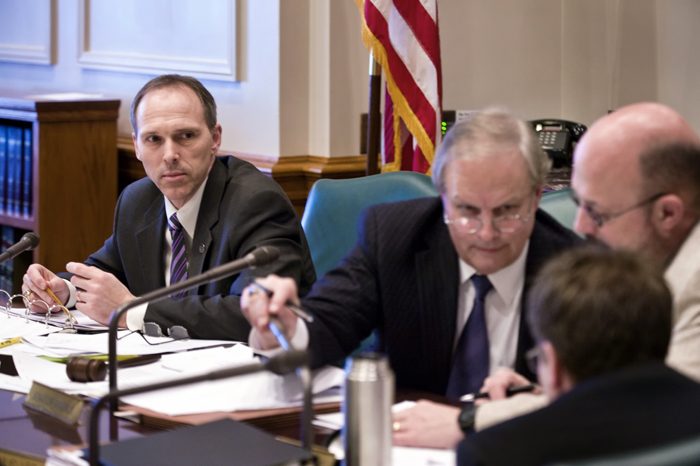 During an April 11 conference committee, Rep. Rod Hamilton, left, chairman of the House Agriculture and Rural Development Policy and Finance Committee, waits as Sen. Doug Magnus, top center, chairman of the Senate Agriculture and Rural Economies Committee talks with Senate staff, Greg Knopff, right, and Daniel Mueller to get their reaction to a motion to accept a House section of the bill. (Photo by Tom Olmscheid)