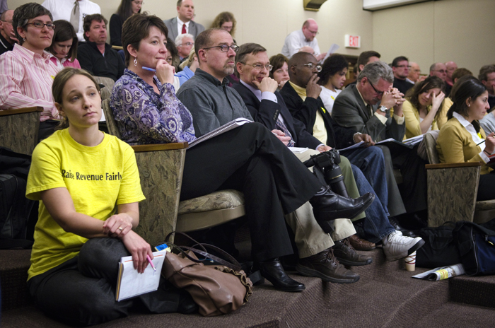 Invest in Minnesota Outreach Coordinator Leah Gardner wears a Raise Revenue Fairly shirt as she listens to testimony on Gov. Mark Daytons tax plan during the April 13 meeting of the House Taxes Committee. (Photo by Tom Olmscheid)