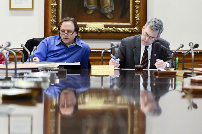 During an April 12 conference committee, Rep. Jim Abeler, left, and Sen. David Hann listen to a side-by-side comparison of revenues and expenditures among the House, Senate and governors versions of the omnibus health and human services finance bill. (Photo by Andrew VonBank)