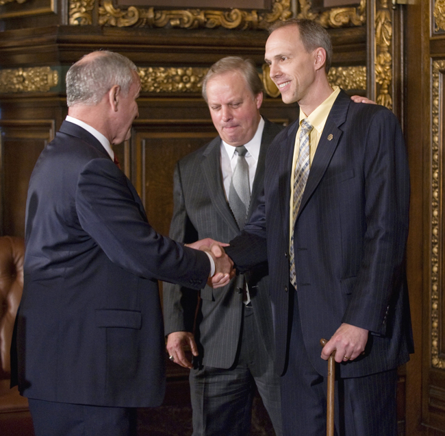 Rep. Rod Hamilton, right, gets a handshake from Gov. Mark Dayton and a pat on the back from 
Sen. Doug Magnus after Dayton signed the omnibus agriculture budget law, during an April 15 signing ceremony. (Photo by Tom Olmscheid)