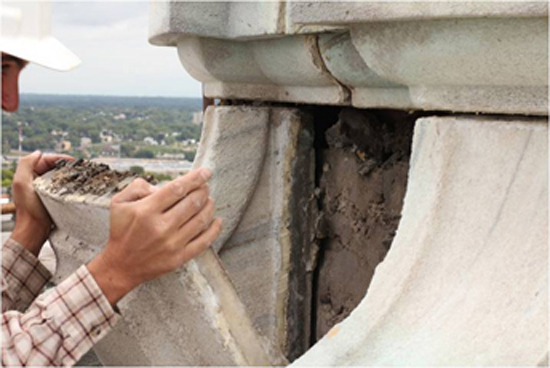 A worker examines deterioration around a panel of marble near the finial (the top of the Capitol dome). The building�s damaged masonry is among the many problems lawmakers hope to address. (Photo courtesy of the Department of Administration)