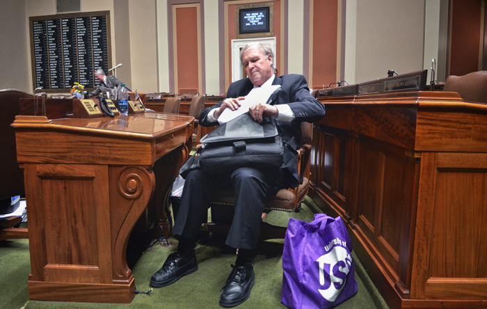 With the date and time when the House is scheduled to reconvene on the Vote Register above his head, Rep. Dean Urdahl packs up paperwork and personal items from his Chamber desk after the House adjourned the 2011 legislative session. (Photo by Tom Olmscheid)
