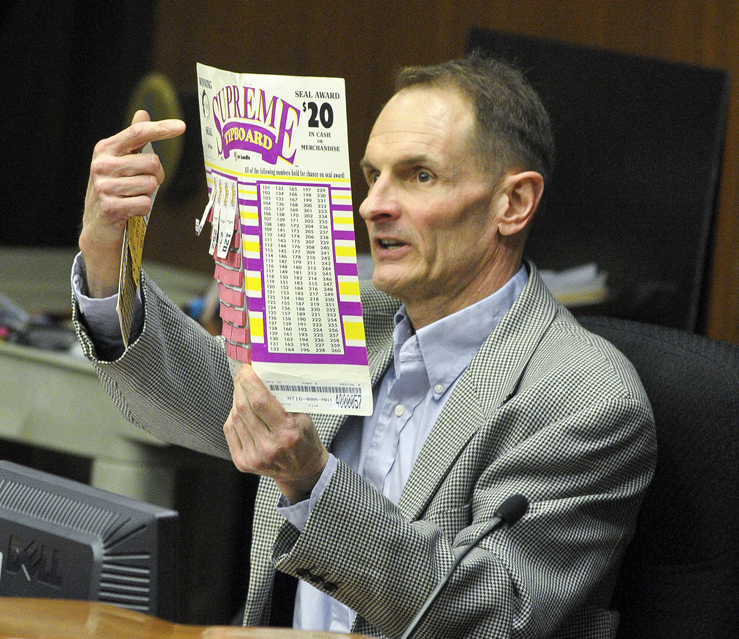 King Wilson executive director of Allied Charities, shows members of the House Commerce and Regulatory Reform Committee an example of tip board numbers during discussion of a bill that help would provide funding for a new stadium to house the Minnesota Vikings. (Photo by Andrew VonBank)
