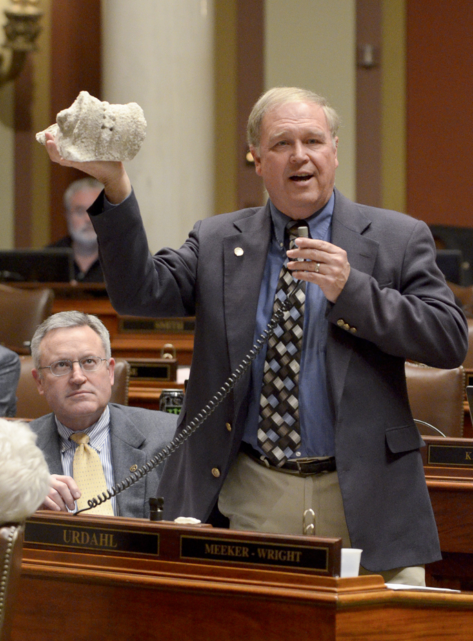 To illustrate the need for repairs, Rep. Dean Urdahl holds up a stone scroll that fell off the State Capitol. The House failed to pass a bill April 19 that would provide $221 million to restore the building. (Photo by Andrew VonBank)