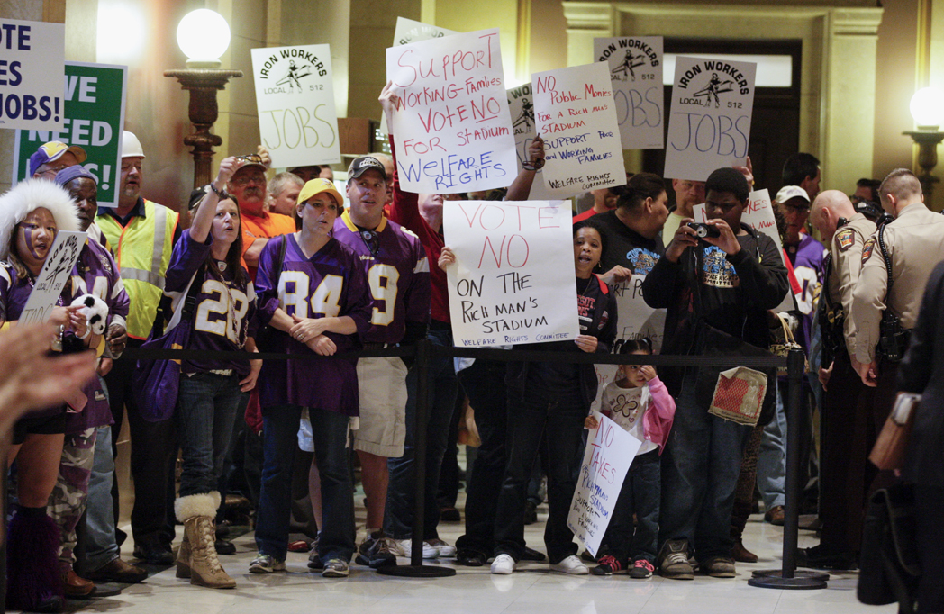 Vikings stadium supporters and opponents stand side-by-side outside the House Chamber May 7. The House passed its version of the stadium bill that day. The final bill was passed three days later. (Photo by Paul Battaglia)